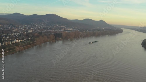 Cinematic drone /aerial shot of the river rhine with a ship and the panorama of the seven mountains / Siebengebirge Königswinter / Bonn at golden hour, 30p photo