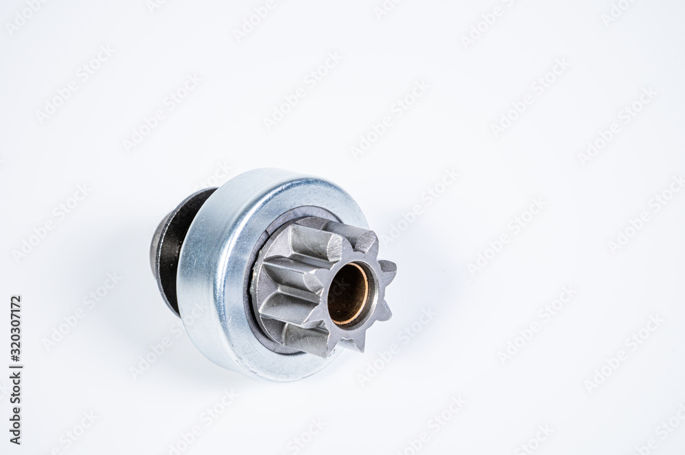 New spare parts - starter gear drive for motor starter on a gray background. Classic gear transmission via torque transmission New spare parts - starter gear drive for motor starter on a gray background. Classic gear transmission via torque transmission