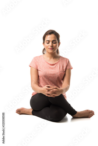 Indian Woman / Girl performing Yoga asana or meditation or dhyan, sitting isolated over white background photo