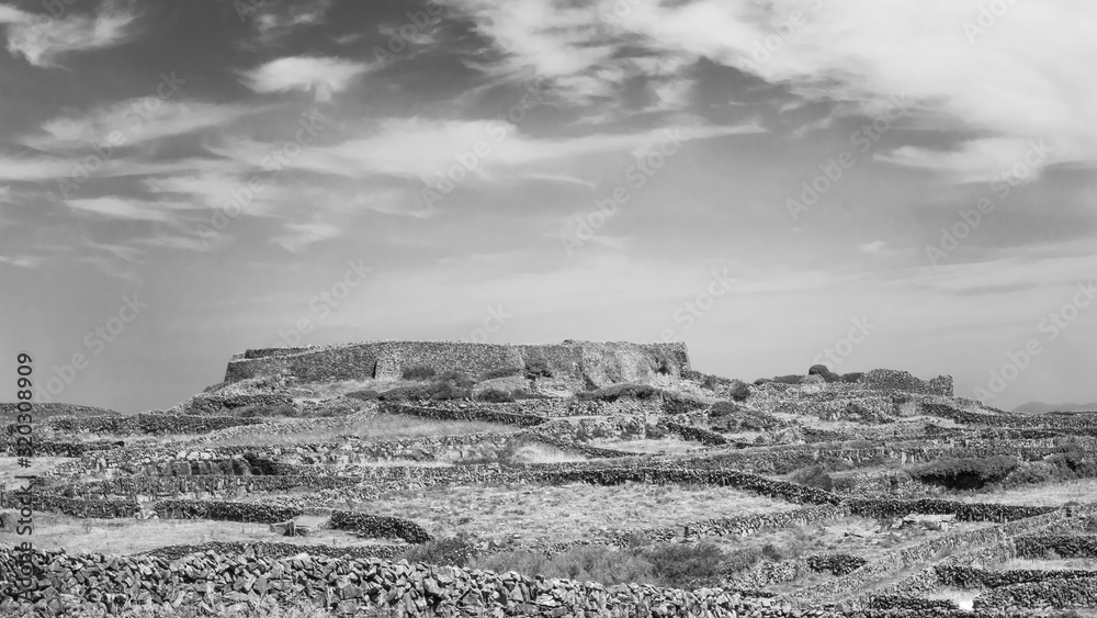 Black and white shot of the rugged stone landscape and characteristic dry stone walls on Inishmaan, one of the Aran Islands off the west coast of Galway, Ireland. Black and white shot of the rugged stone landscape and characteristic dry stone walls on Inishmaan, one of the Aran Islands off the west coast of Galway, Ireland.