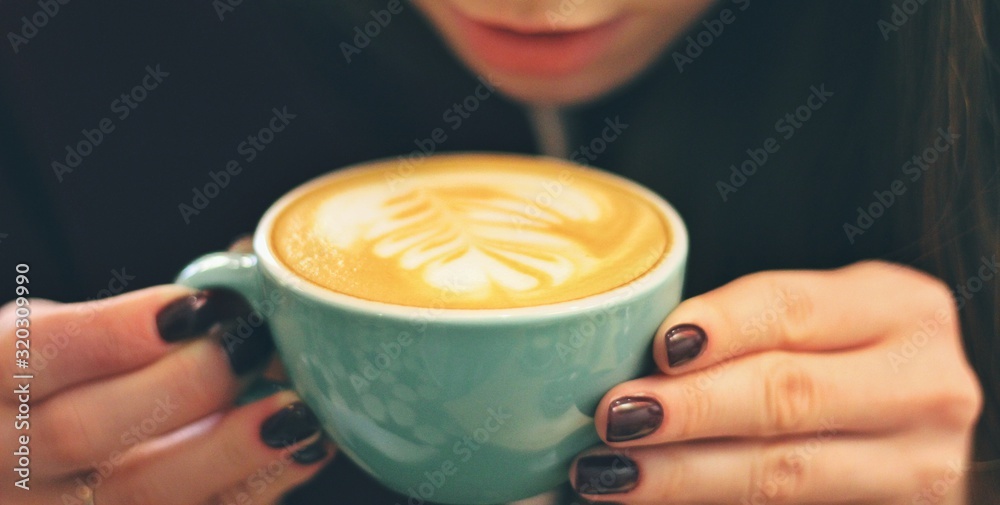 Caucasian young woman enjoying coffee drinking in cafe, close up