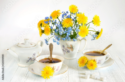 Fototapeta Naklejka Na Ścianę i Meble -  Bouquet of spring flowers. Spring still life of dandelions, forget-me-nots and cups of tea. Isolated on white background
