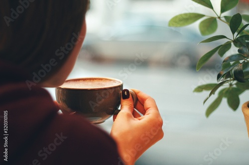 Caucasian young woman enjoying coffee drinking in cafe, close up
