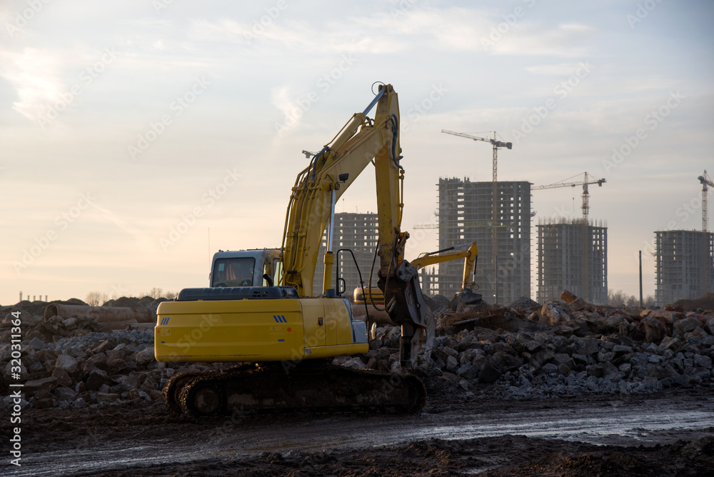 Excavator with hydraulic shears on a construction site cuts and crumbles old concrete and asphalt. Hydraulic breaker grinder. Crusher concrete slabs, breaker crushes, hydraulic shears. Excavator with hydraulic shears on a construction site cuts and crumbles old concrete and asphalt. Hydraulic breaker grinder. Crusher concrete slabs, breaker crushes, hydraulic shears.