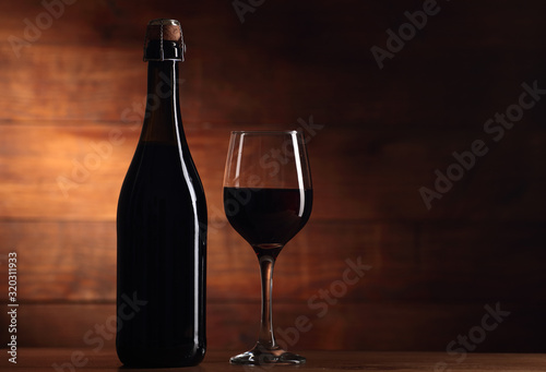 full wine bottle without label with goblet