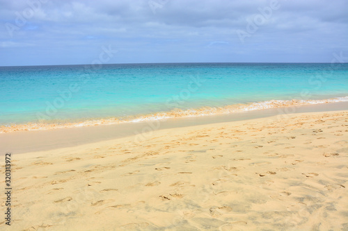 Natural background, a beautiful sandy beach and turquoise, blue calm. ocean, sea with a clear horizon on a sunny day on Sal Island in Cape Verde, Cabo Verde