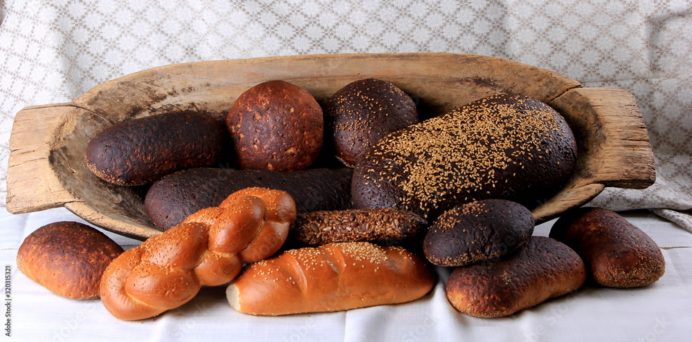 Fresh collection of bread and wheat on the table. Collection of different types of bread: White, rye, seed, form bread. lots of photos of bread with rye ears Fresh collection of bread and wheat on the table. Collection of different types of bread: White, rye, seed, form bread. lots of photos of bread with rye ears
