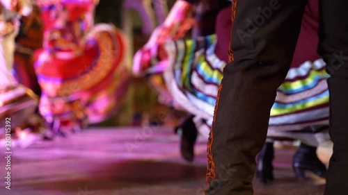 Stunning slow motion of Mexican dresses twirling as couples move in a folk dance.