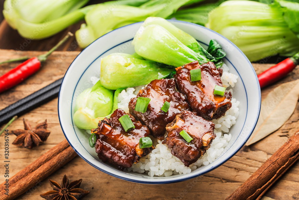 A bowl of rice with ribs in brown sauce A bowl of rice with ribs in brown sauce
