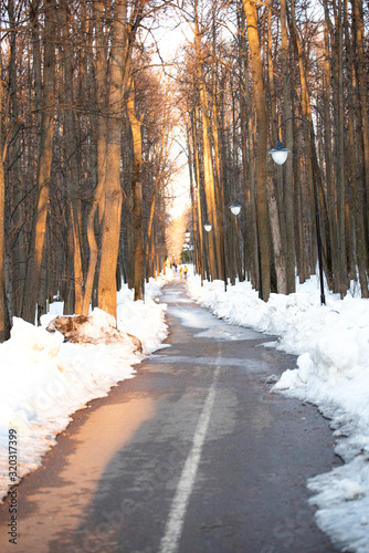 Early spring with snow in a beautiful city Park with trees