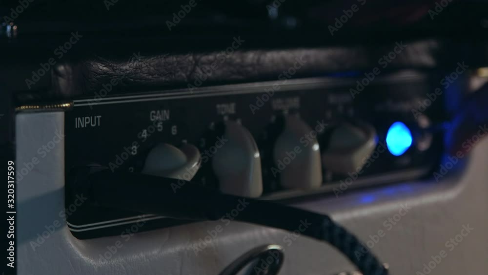 Close up of Hand Put in Aux Cable and Turn on Amplifier Close up of Hand Put in Aux Cable and Turn on Amplifier