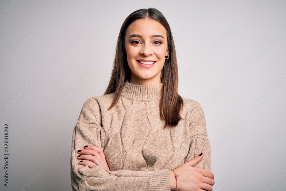 Young beautiful brunette woman wearing casual sweater standing over white background happy face smiling with crossed arms looking at the camera. Positive person. Young beautiful brunette woman wearing casual sweater standing over white background happy face smiling with crossed arms looking at the camera. Positive person.