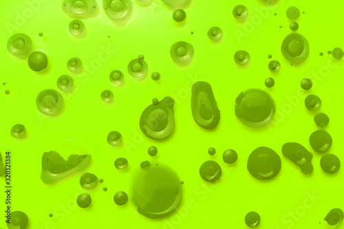  Abstract background from drops of green paint on a green glass.