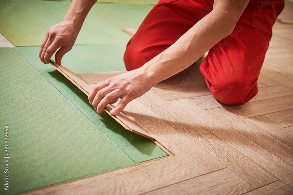 worker laying laminate floor covering at home renovation - obrazy, fototapety, plakaty 
