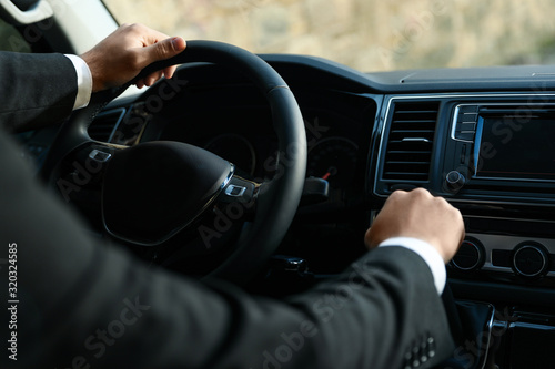 Professional driver in luxury car, closeup. Chauffeur service photo