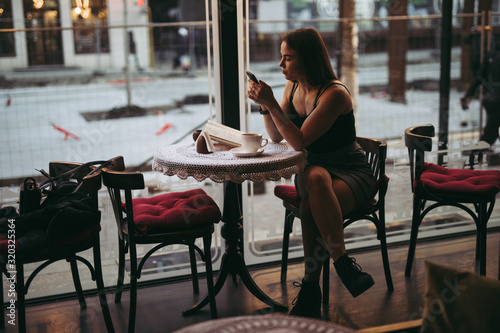 Woman playing with smartphone in cafe