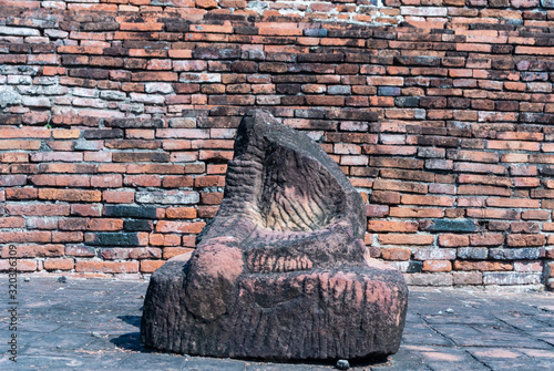 Old sand stone buddha image statuie and old brick wall of temple photo