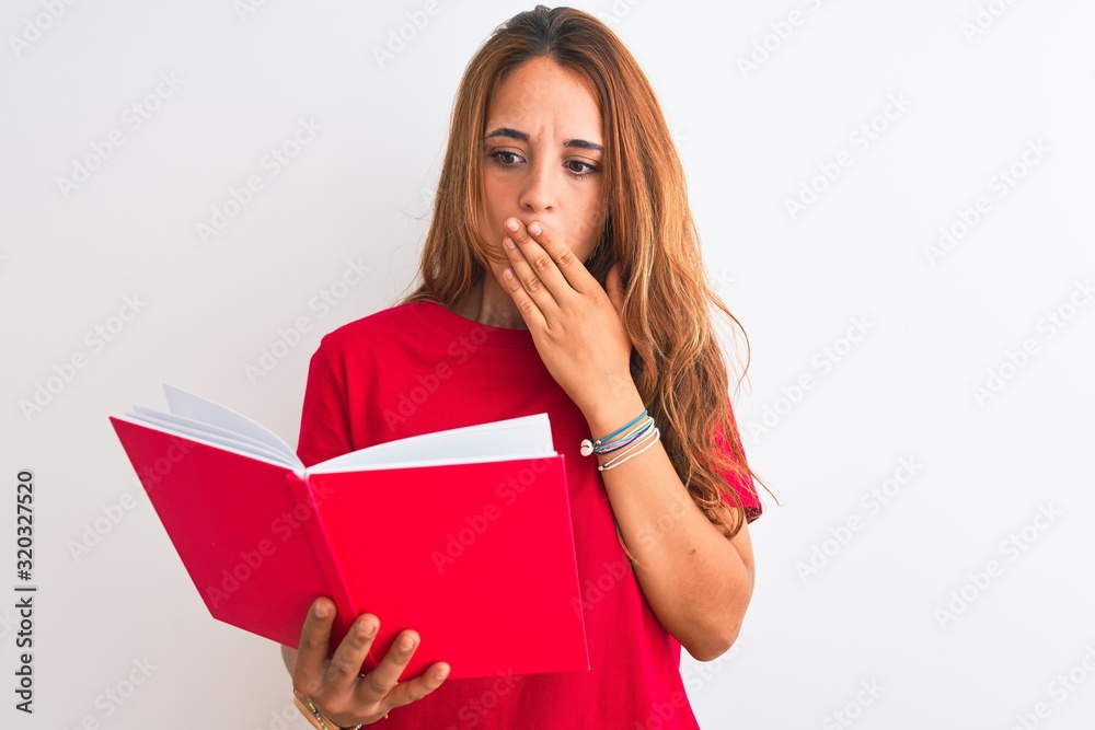 Young beautiful redhead woman reading a red book over isolated background cover mouth with hand shocked with shame for mistake, expression of fear, scared in silence, secret concept Young beautiful redhead woman reading a red book over isolated background cover mouth with hand shocked with shame for mistake, expression of fear, scared in silence, secret concept