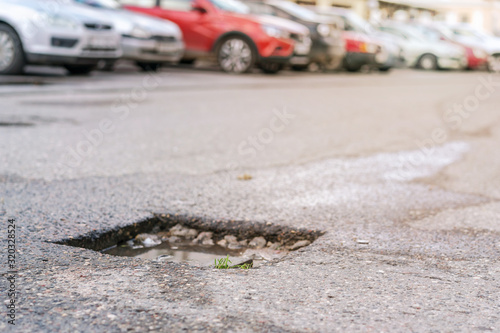 pothole with water after rain on asphalt roadway