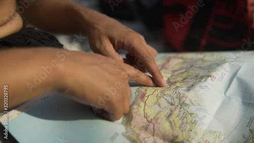 close up of  caucasian young hands showing a route on the map at summer vacation, slow motion b roll2 photo