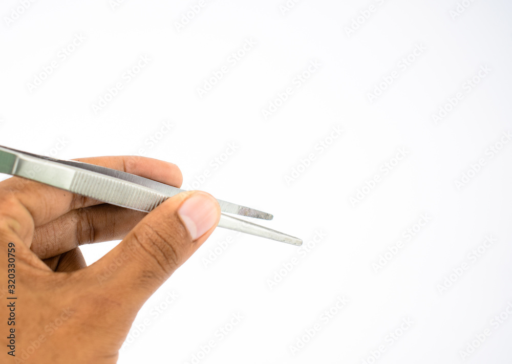 Close up picture of a person holding a tweezers in his hand in front of a white background Close up picture of a person holding a tweezers in his hand in front of a white background