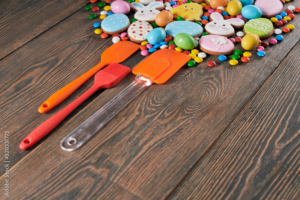 Colorful easter cookies and spatulas on table.
