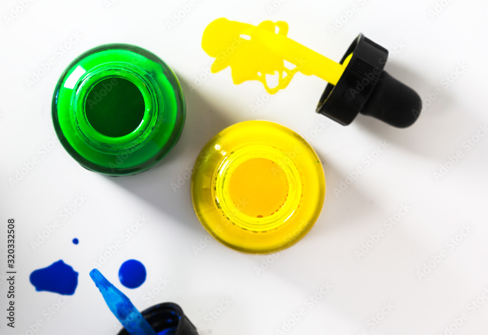 Glass bottle with acrylic paint on white background