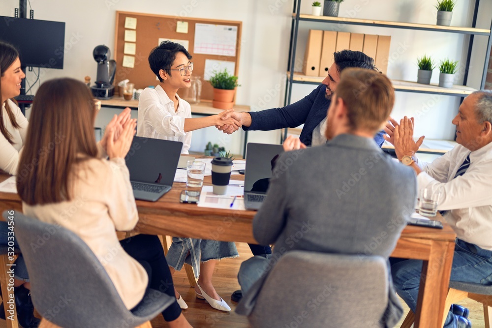 Group of business workers smiling happy and confident. Working together with smile on face shaking hands at the office Group of business workers smiling happy and confident. Working together with smile on face shaking hands at the office