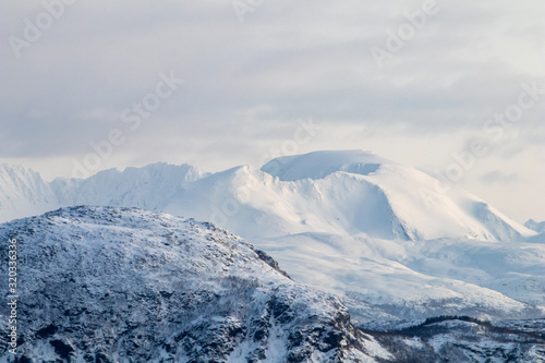 Mountain silhouette profile in arctic landscape with snow and ice. Snowy mountain on a blue sky and clouds, profile of a mountain with snow and ice. Winter landscape © PAOLO