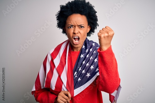 Young African American afro woman with curly hair wearing united states of america flag annoyed and frustrated shouting with anger, crazy and yelling with raised hand, anger concept
