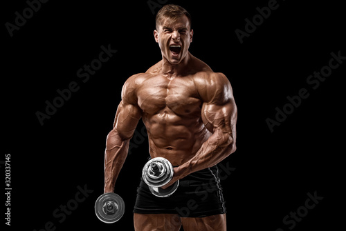 Muscular man with dumbbells working out isolated on black background. Strong male naked torso abs