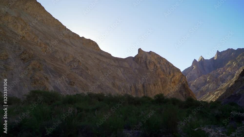 Dolly reveal shot to the left of a bald mountain range in the wilderness, from behind a tree, Dolly reveal shot to the left of a bald mountain range in the wilderness, from behind a tree,