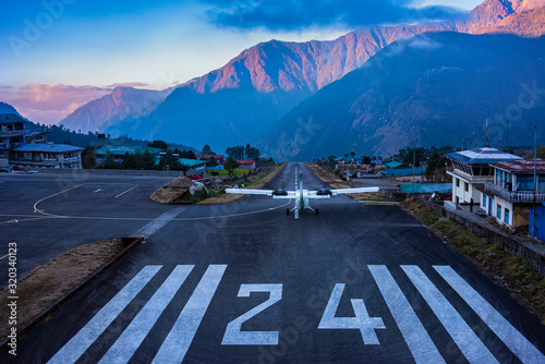 Lukla, NEPAL - December 2, 2019: Lukla airport. In the frame of the airport runway and taking off the plane. Nepal. Everest trekking. photo