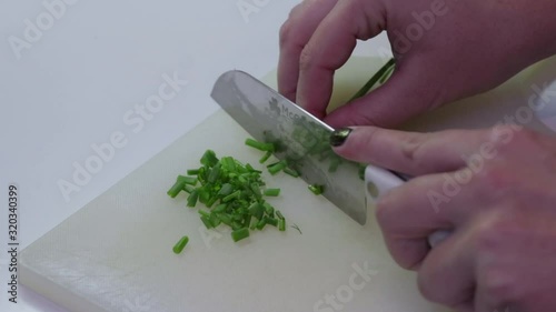 Slicing Chives in the kitchen with a knife photo