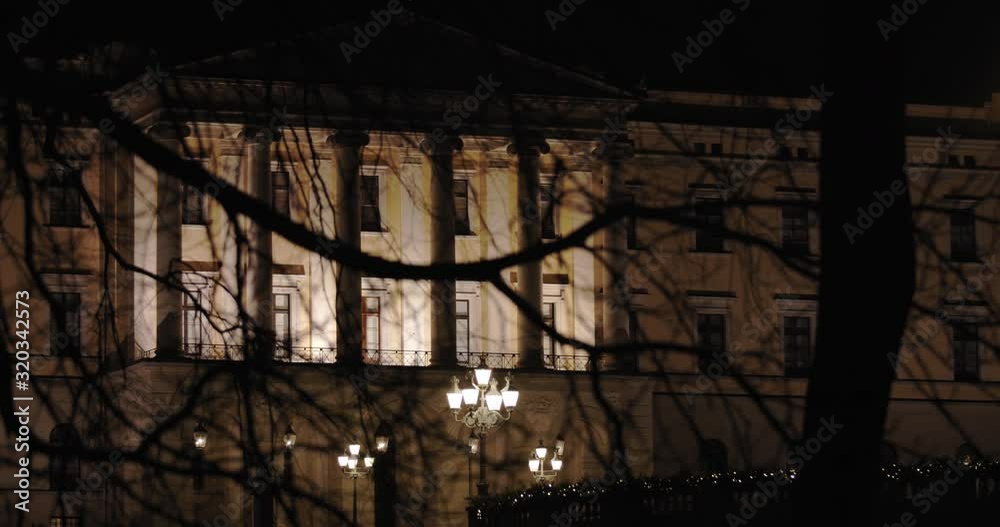 Cinematic slow motion medium wide 4K shot with parallax motion of the illuminated royal palace and the iconic balcony on top of Karl Johan street at night, in Oslo Norway. Cinematic slow motion medium wide 4K shot with parallax motion of the illuminated royal palace and the iconic balcony on top of Karl Johan street at night, in Oslo Norway.