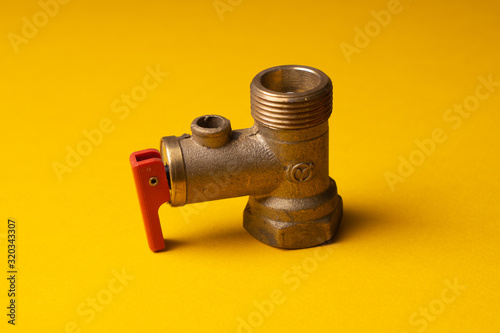Bronze Check Valve. Non-return valve for water in the electric water heater system. On a yellow background.