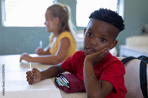 Schoolboy sitting at a desk in an elementary school classroom