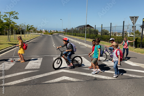 Fotografiet Group of schoolchildren on a pedestrian crossing