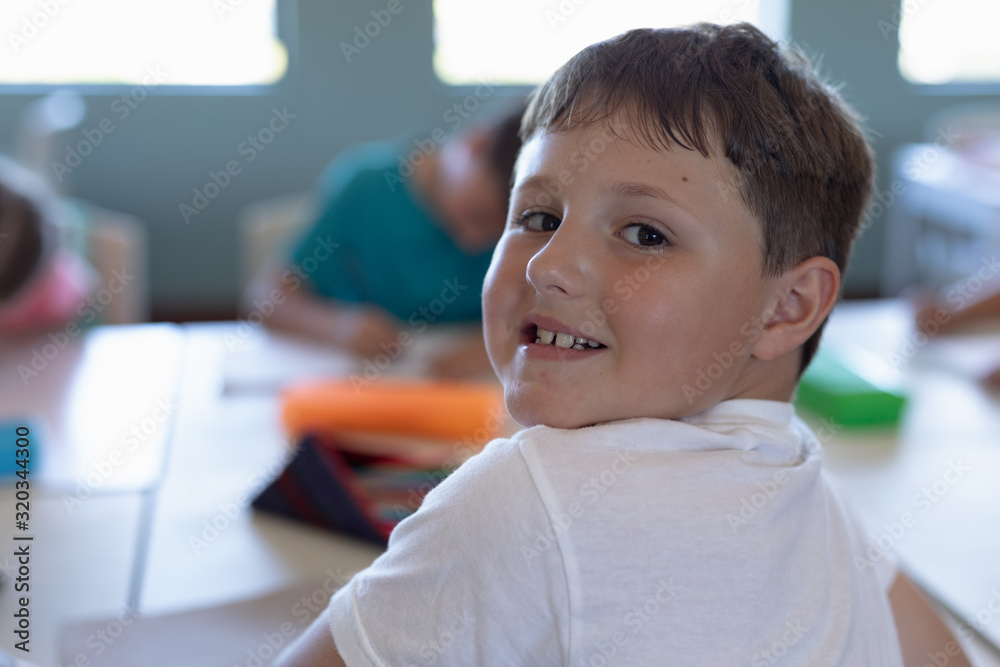Schoolboy sitting at a desk in an elementary school classroom Schoolboy sitting at a desk in an elementary school classroom