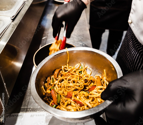 chef cooking noodles in the restaurant photo