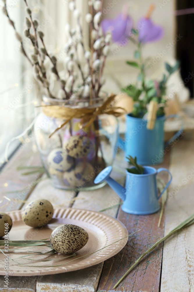 Easter decoration, eggs, pussy-willow branches fur seals on a wooden surface on a window background