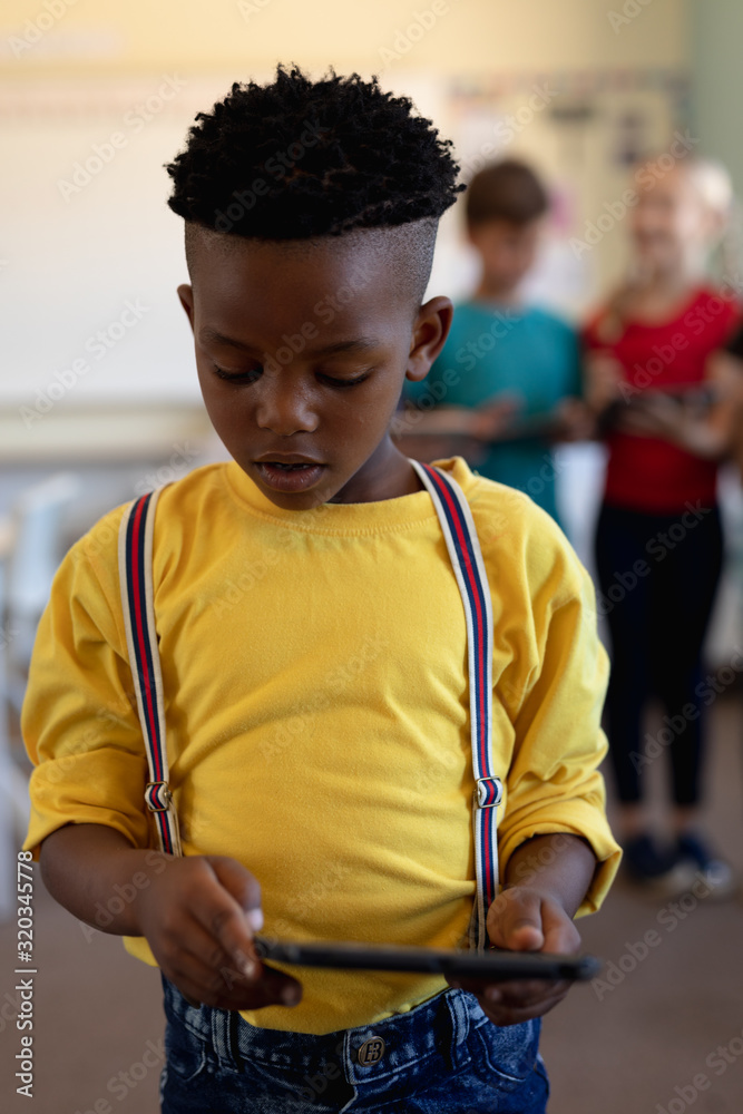 Schoolboy using a tablet computer in an elementary school classroom Schoolboy using a tablet computer in an elementary school classroom