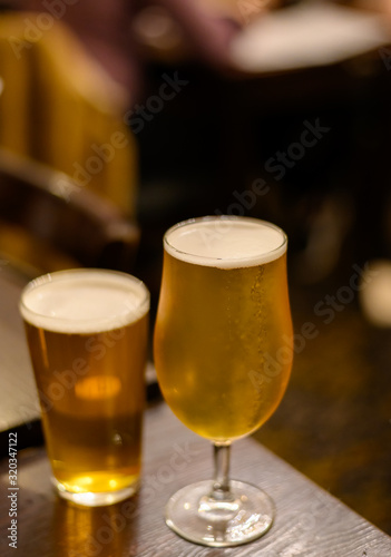 Misty glasses with two pints of cold Scotch ale, pale ale, lager draft beer in English pub