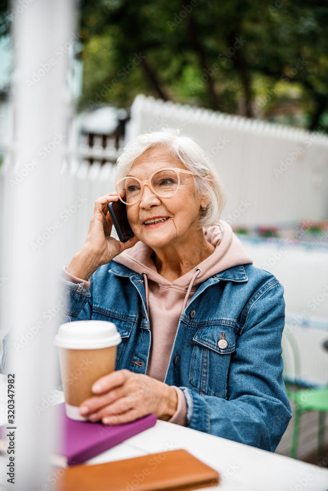 Smiling grandmother with coffee making call stock photo Smiling grandmother with coffee making call stock photo