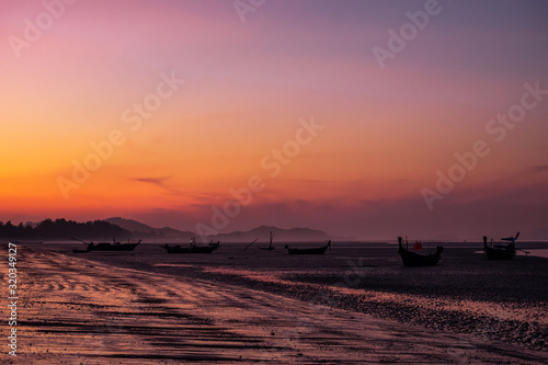 fishing boat with sunset on the beach