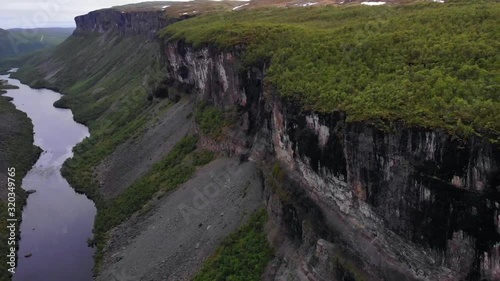 Aerial, pan, drone shot overlooking the Altaelva river, the Alta canyon and the nature surrounding it, on a cloudy day, in Finnmark, north Norway photo