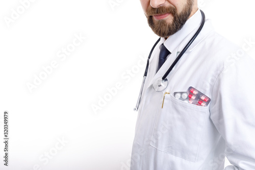 Canvas Print Cropped image of bearded doctor in smock with stethoscope and various pills and