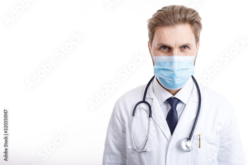 Concentrated doctor in white smock and medical mask giving a gaze isolated white background copyspace
