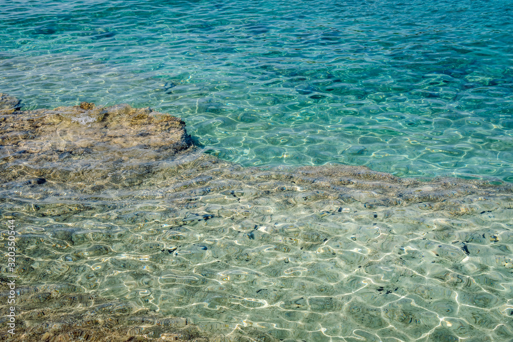 Clear turquoise sea water surface texture. Adriatic sea near Premantura peninsula, Istria, Croatia.