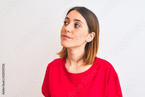 Beautiful redhead woman wearing casual red t-shirt over isolated background smiling looking to the side and staring away thinking. © Krakenimages.com
